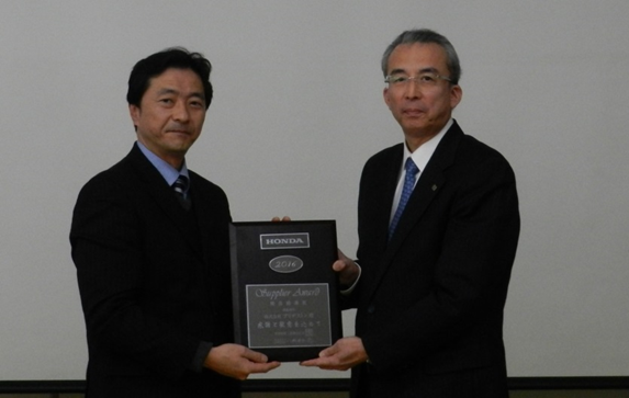 Hiroshi Saito (left), Honda Motor Co.'s general manager of the purchasing global operations planning office, presents the Environmental Award to Yutaka Yamaguchi (right) , Bridgestone’s vice president and senior officer responsible for safety, disaster prevention and quality.