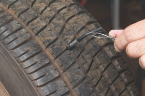 7. while the cement is still wet, push the wire puller through the injury from the inside of the tire. grasping the wire, use a steady pull until -inch of the gray rubber on the plug is exposed outside the tire.