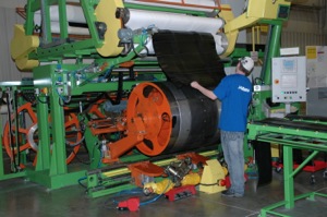 A Mitas employee builds a tire casing with layers of rubber compound-coated fabric on the company's all-new equipment.