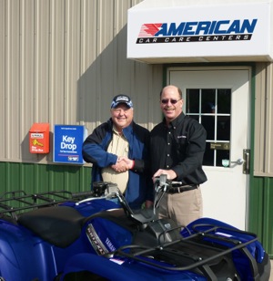 dan hovland of hovland american car care centers in wisconsin dells, wisc., (left) accepts an atv from bill ammann of usautoforce.