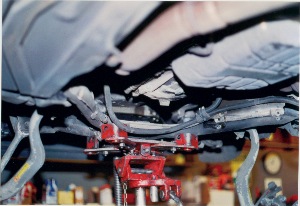 photo 1: by lowering the subframe about two inches at the rear and twisting the bar, we could remove it without having to completely remove the suspension support.
