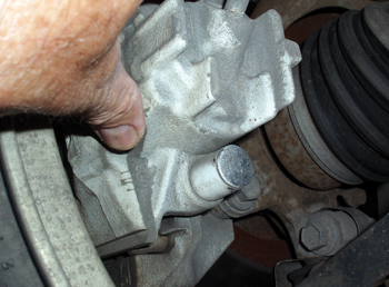 photo 1: loose or worn brake caliper mountings are common noise generators. always install new mounting hardware and torque mounting bolts to specification.