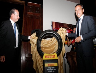 Rafael Navarro (left), PTNA vice president of communications, and Paolo Ferrari, chairman and CEO, unveil the first tire produced at the tiremakers plant in Rome, Ga., now on permanent display at the Rome Area History Museum.