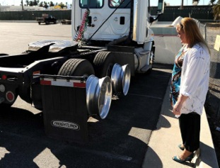 Tracylyn Sharrit, director of marketing for Second Harvest Food Bank, with one of the damaged trucks. (Photo courtesy of Valley Daily Bulletin) 