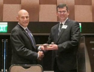 Outgoing TIA president Randy Groh (left) passes the gavel to new president Ken Brown.