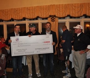 Phil Berra, president of Community Wholesale Tire, presents a $50,000 check to David Feherty for his Troops First Foundation.