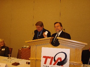 Incoming TIA president, flashing his new name badge, takes the reins of the association from outgoing president Dan Beach (right).