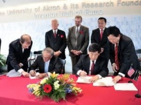 University of Akron president Dr. Luis Proenza and Triangle Group chairman Dr. Yu Hua Ding sign the cooperation agreement.