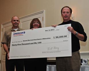 From left, David Brown, community development coordinator/child hunger programs for Second Harvest Food Bank of Metrolina, and Kathy Helms, manager of agency services and programs, accept a $35,000 contribution from American Tire Distributors president and CEO Bill Berry.