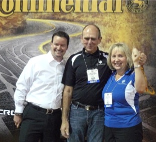 Travis Roffler, Continental Tire director of marketing (left), with Henry Biedrzycki and his wife, who were presented the keys to a pair of Porsches as the winners of the 2011 Continental Tire Dream Giveaway.