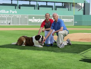 Boston Red Sox second baseman Dustin Pedroia with Sullivan Tire vice president Paul Sullivan, and Misty the dog.